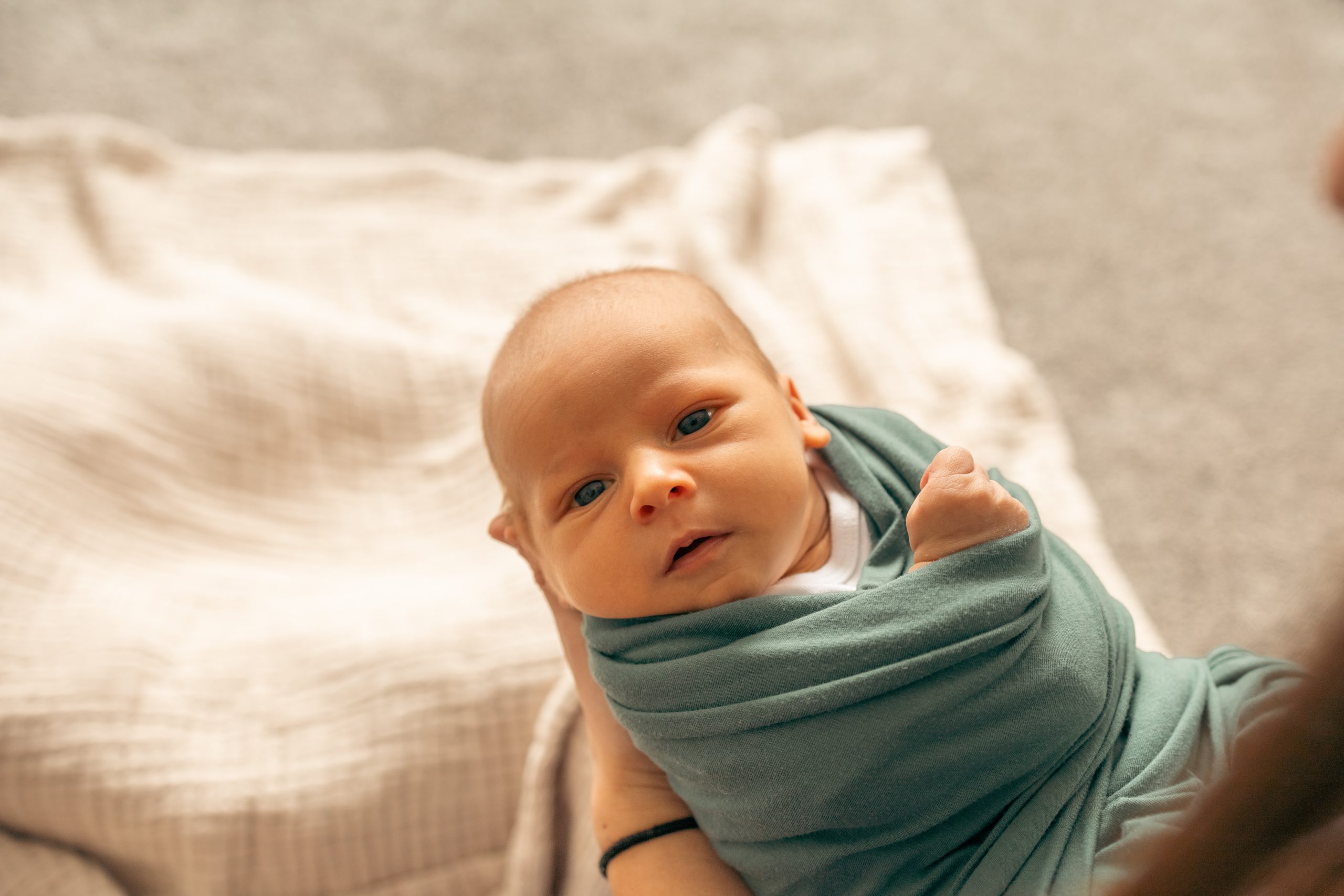 A mother holds her swaddled baby.